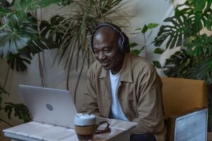 Photo of an Old Man Happily Smiles in Front of Laptop